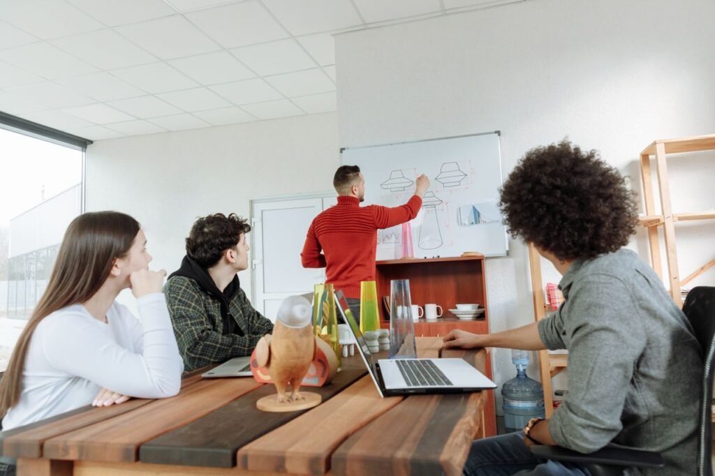 Group of young adults collaborating on design ideas in a modern office setting.